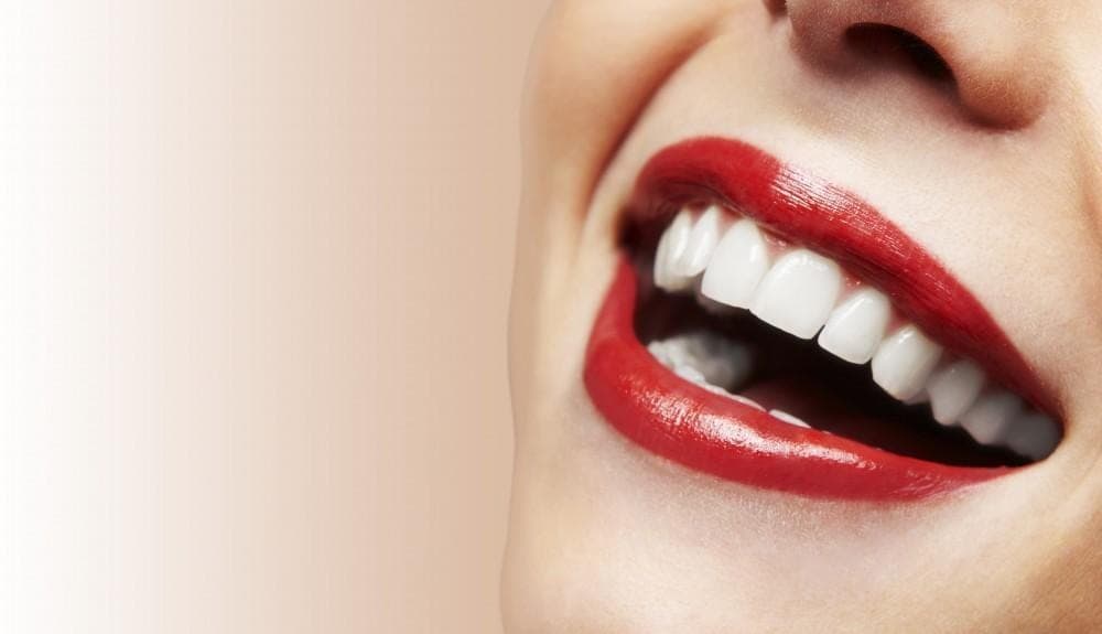 Close-up of a smile with red lipstick and white teeth