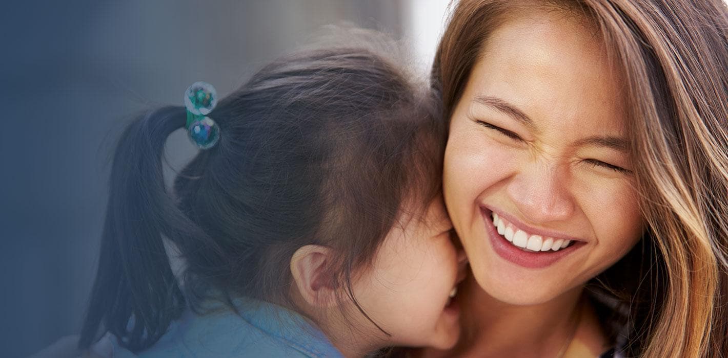 A mother and her young daughter laughing together