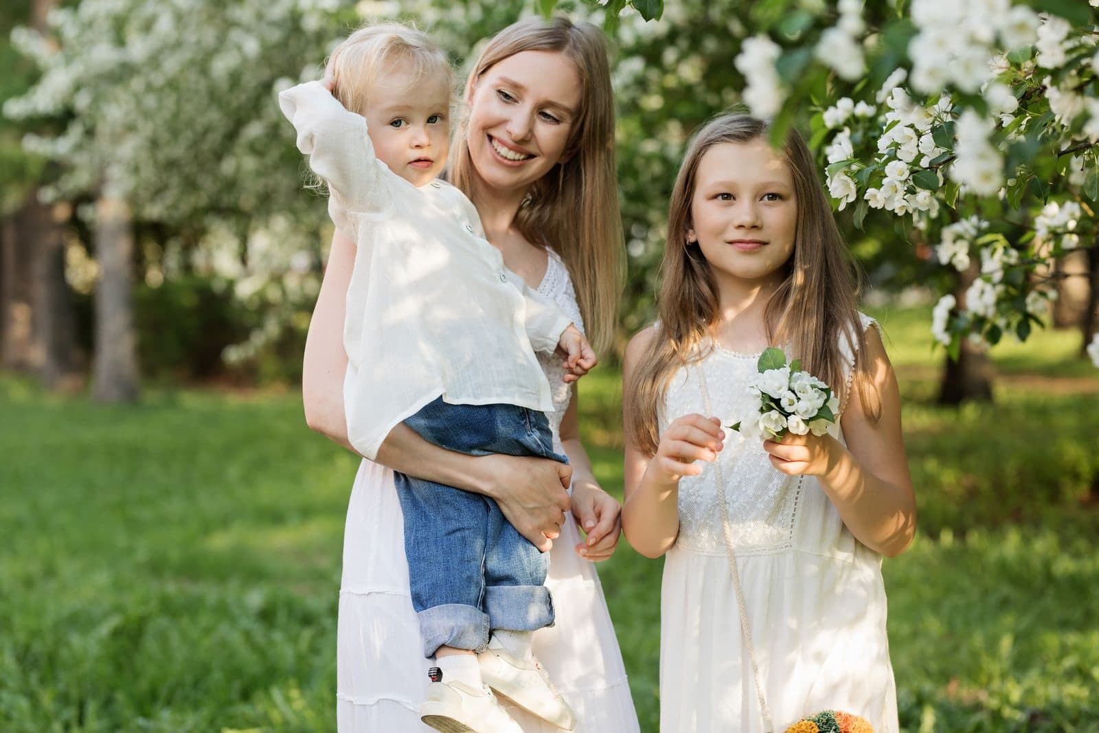 A mother and her two daughters among blossoming trees